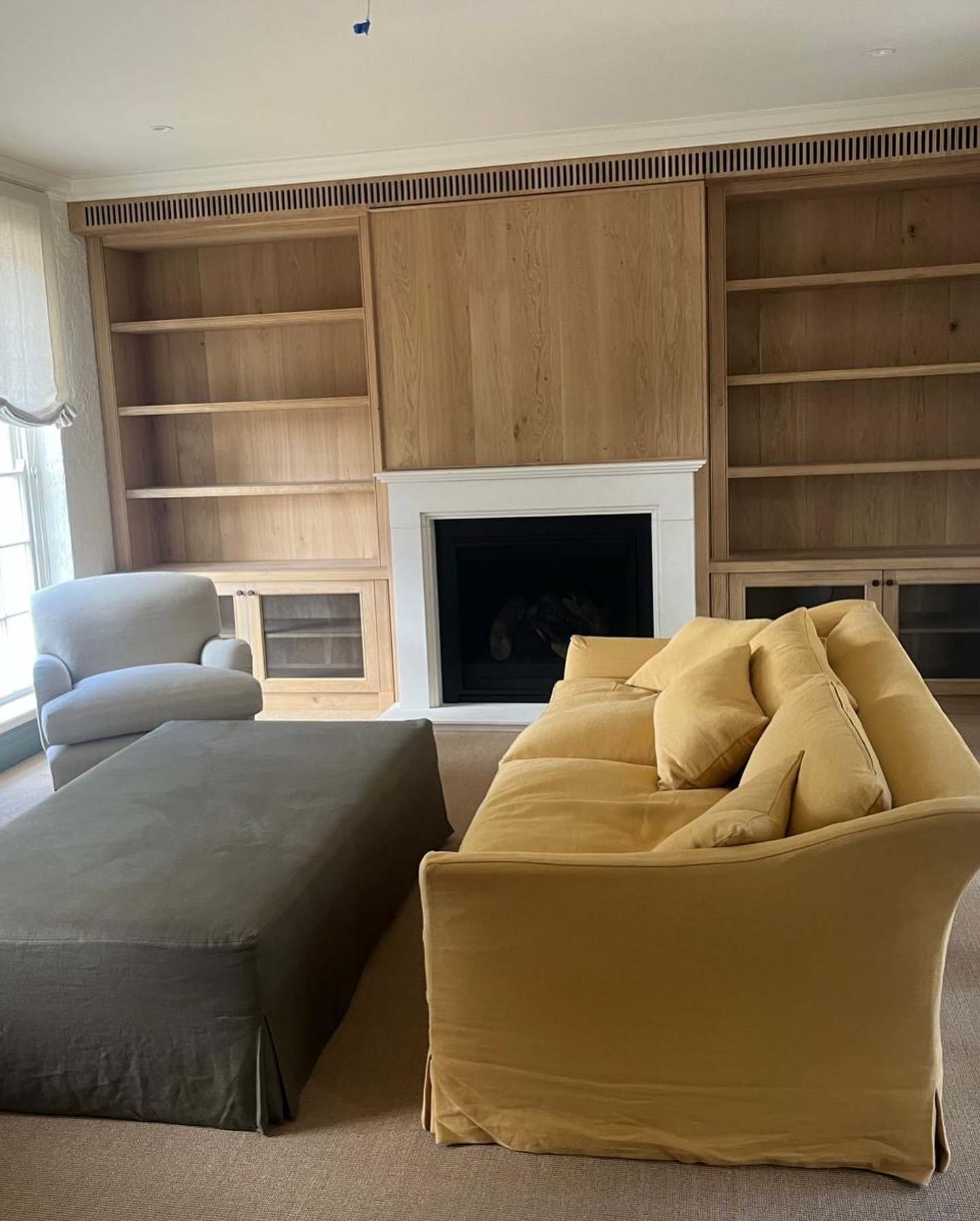 Living room joinery wall with fireplace and a mustard sofa